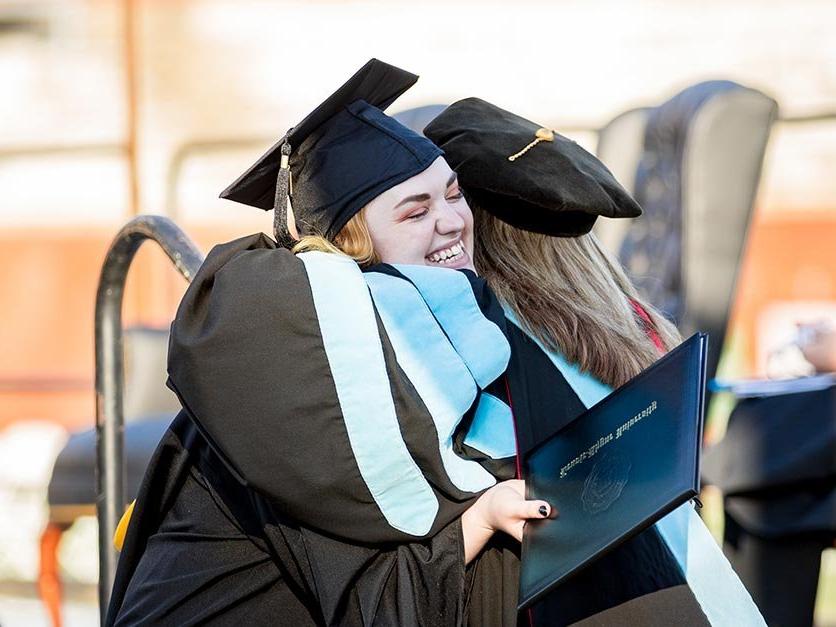 Graduating students hug